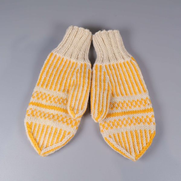 Stickade tumvantar i gult och vitt liggande platt