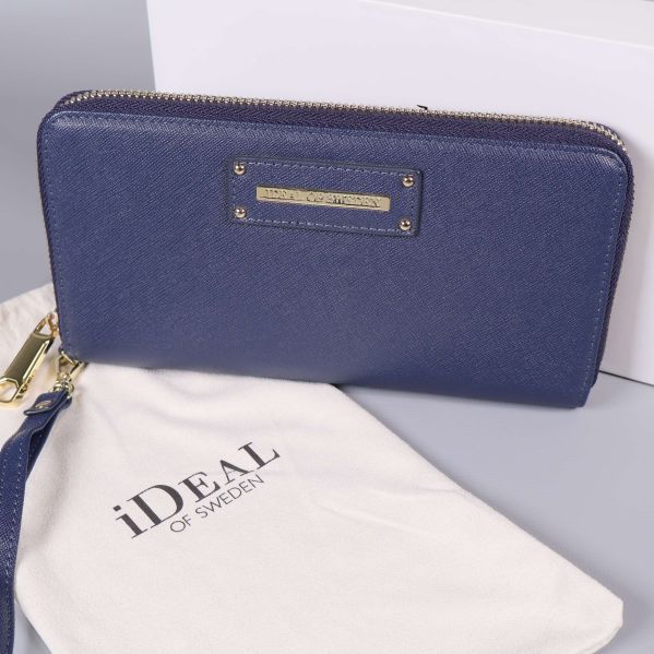 Närbild på blå plånbok och vit tygpåse