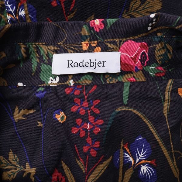 Närbild på Rodebjer-märke inuti blommig jacka