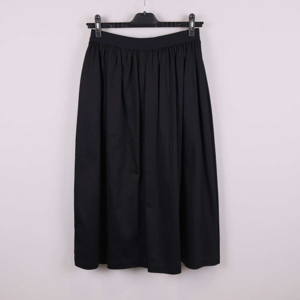 Svart kjol visad från baksidan mot ljus bakgrund