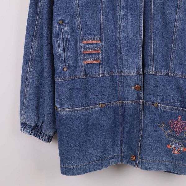 Närbild på fickor och slitningar på jeansjackans framsida