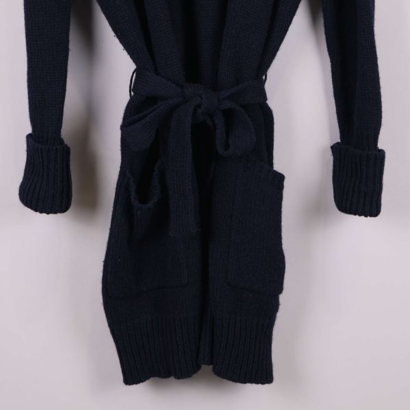 Närbild på fickor och skärp på koftans framsida