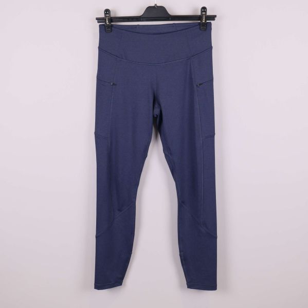 Framsida av blå träningstights på galge mot ljus bakgrund