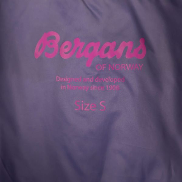 Närbild av rosa Bergans-logotyp på blått tyg