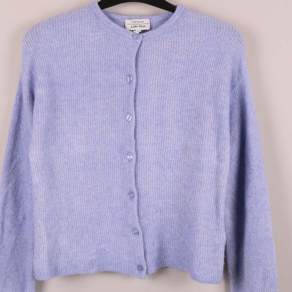 Stickad kofta med närbild på knäppning och struktur