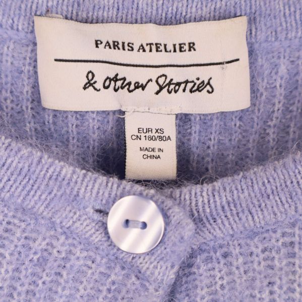 Närbild på varumärkeslapp med texten & Other Stories