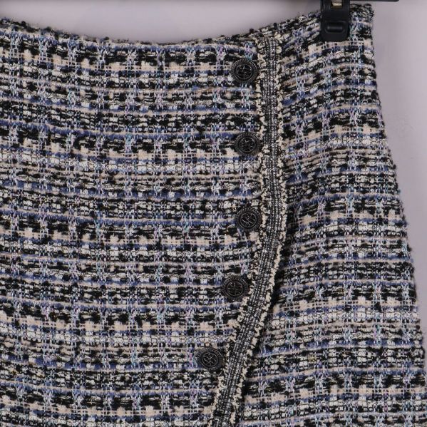 Detaljbild på knappar och mönster framtill på kjolen