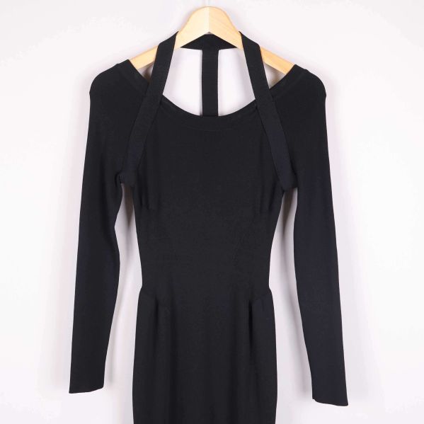 Närbild på överdelen av svart klänning med band vid halsen