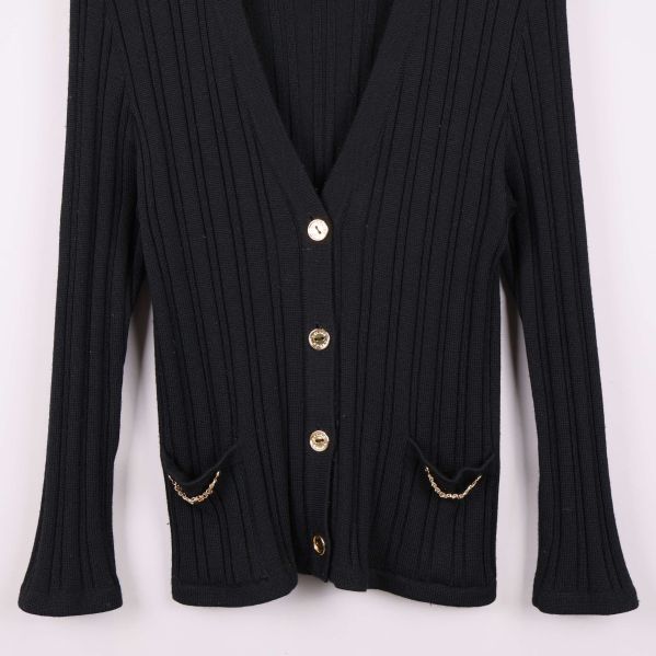 Detaljbild på guldknapp och ribbstickning