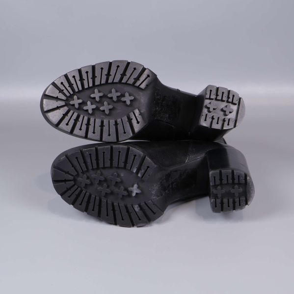  Sula på svarta chelsea boots visas underifrån