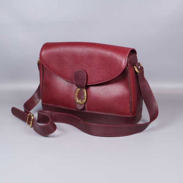 Vinröd axelremsväska i läder med spänne och rem