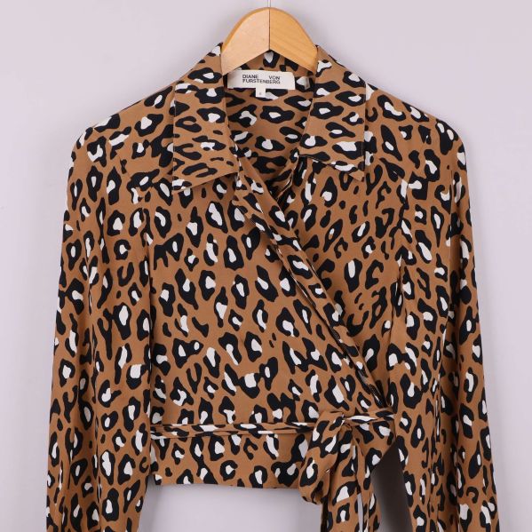 Närbild framtill på omlottblus med knytdetalj