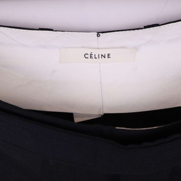 Närbild på Céline-märkesetikett på byxorna