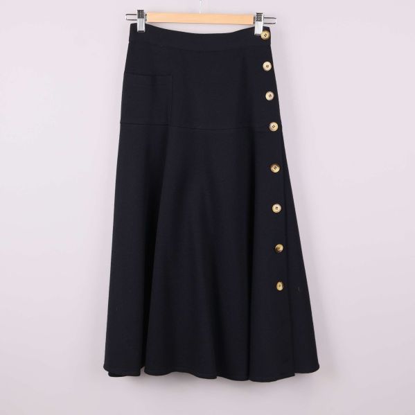 Svart ullkjol med guldknappar framtill, helbild