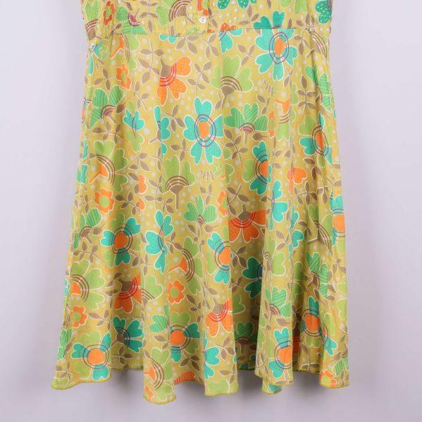 Nederdel av gul klänning med blommigt motiv
