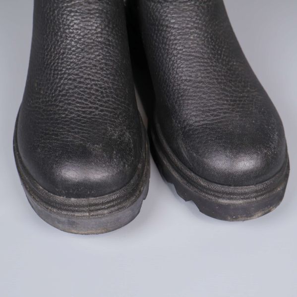 Närbild på tåpartiet av svarta boots