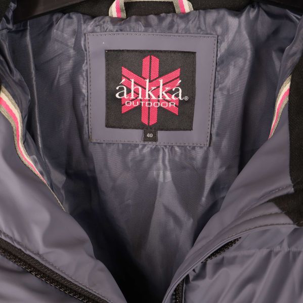 Närbild på áhkká outdoor logotyp i jackans krage