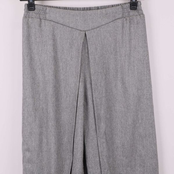 Närbild på överdelen av grå omlottbyxa