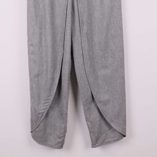 Närbild på benens omlottfinish på grå byxa