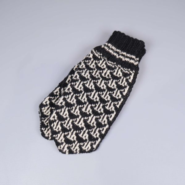 En svartvit stickad tumvante med grafiskt mönster