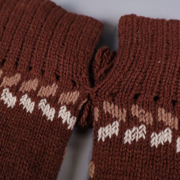 Närbild på mudd och garnrosett på tumvantar