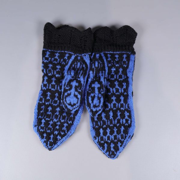 Baksidan på tumvantar med svart och blå design syns tydligt