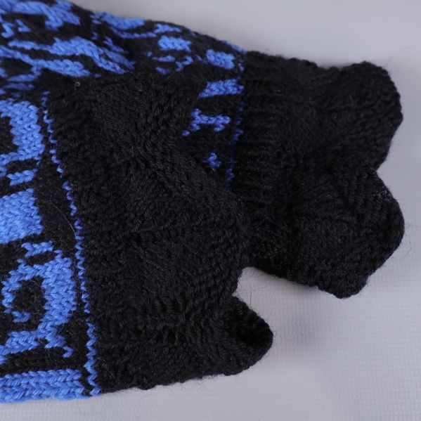 Närbild på mudden på tumvantarna i svart stickat material