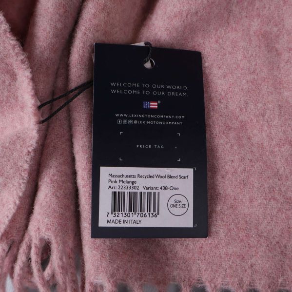 Detaljerad etikett på baksidan av halsduk, visar materialinformation