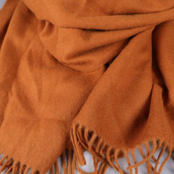 Närbild på orange halsduk med fransar