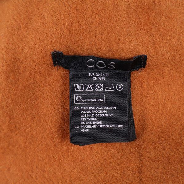 Svart etikett med tvättråd och material för COS halsduk