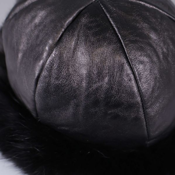 Närbild på mössans släta svarta skinnmaterial