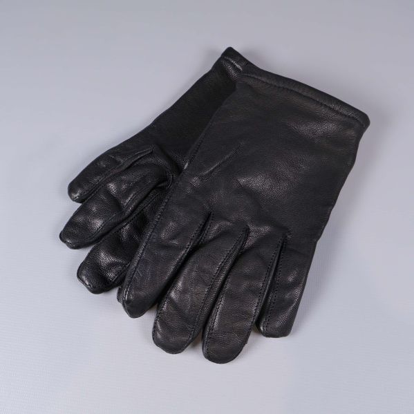 Ett par svarta skinnhandskar liggande på grå yta