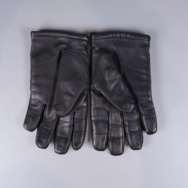 Svarta skinnhandskar i par med handflatan synlig