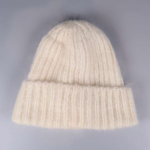 Krämvit stickad mössa sedd bakifrån