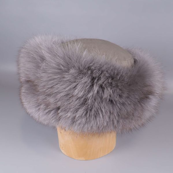 Grå pälsmössa placerad på ett trähuvud