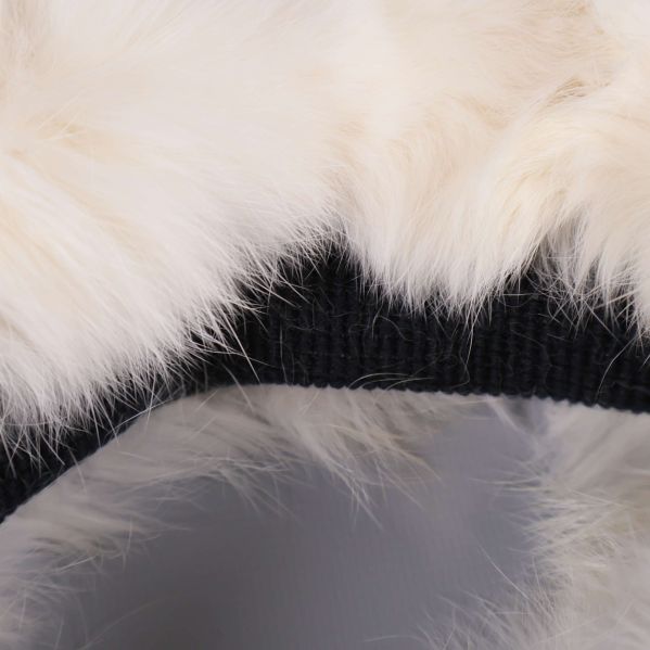 Närbild på vit fluffig yta och svart fodrad insida