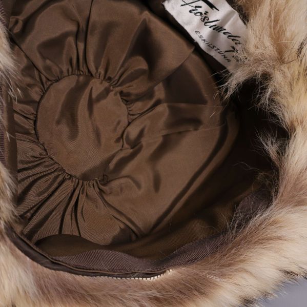 Insida av mössa med brun textil och resår