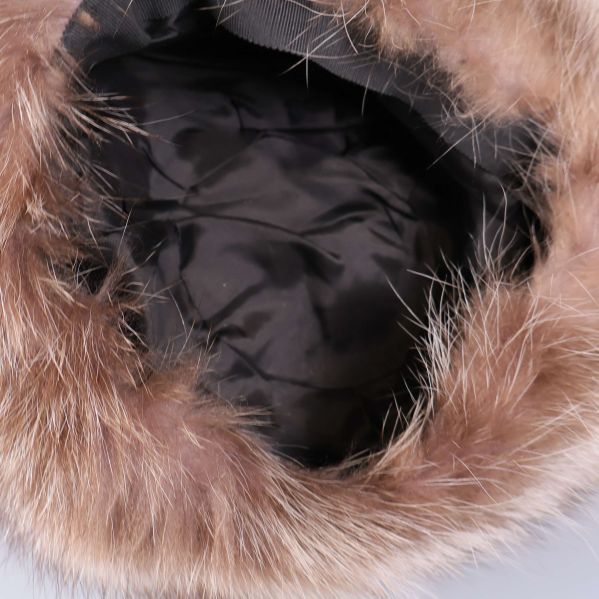 Insidan av mössa med svart fodrad textil och päls