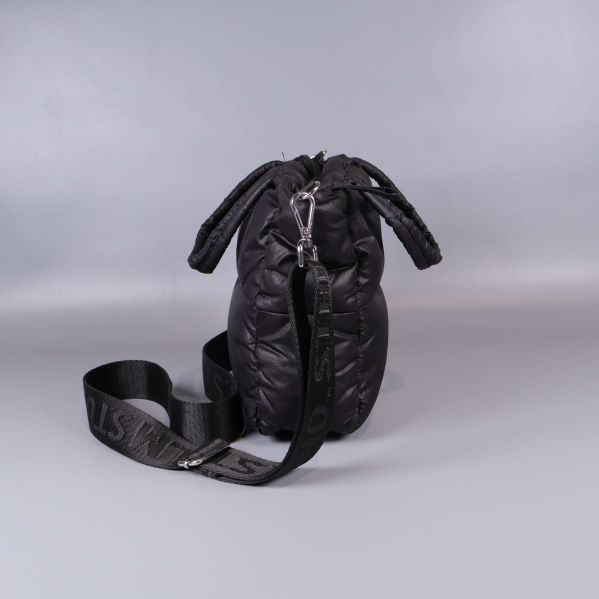 Svart quiltad väska sedd från sidan med avtagbar rem