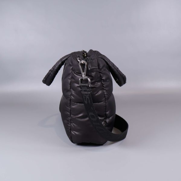 Sidosiluett av svart väska med metallspänne och axelrem