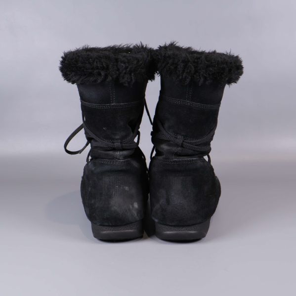 Bakre vy på svarta boots med synlig fluffig kant