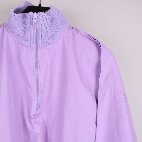 Närbild på ståkrage och dragkedja av ljuslila jacka