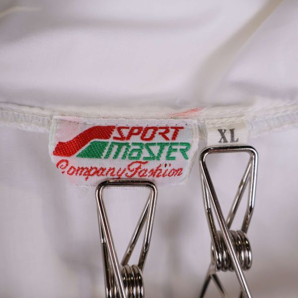 Närbild på Sport Master-etikett och storlek XL i jacka