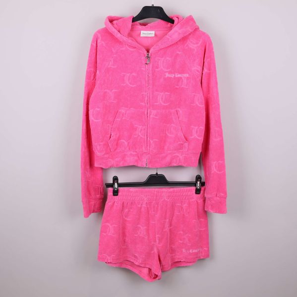 Rosa velourset med hoodie och shorts hängande mot ljus bakgrund