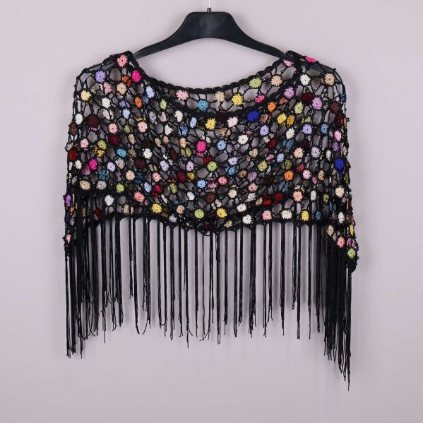 Bakre vy av virkad poncho med färgrika blommor och svarta fransar