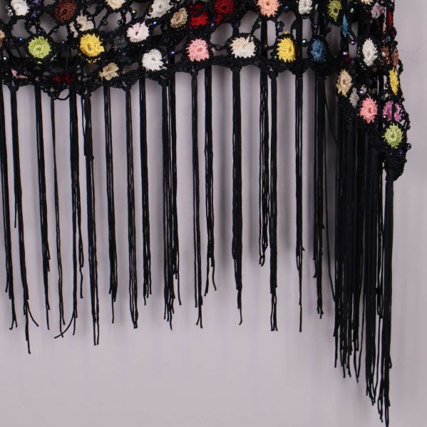 Närbild på ponchons långa svarta fransar