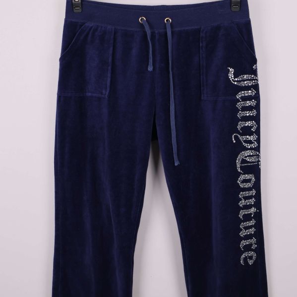 Närbild på framfickor och strasstext på blå byxor