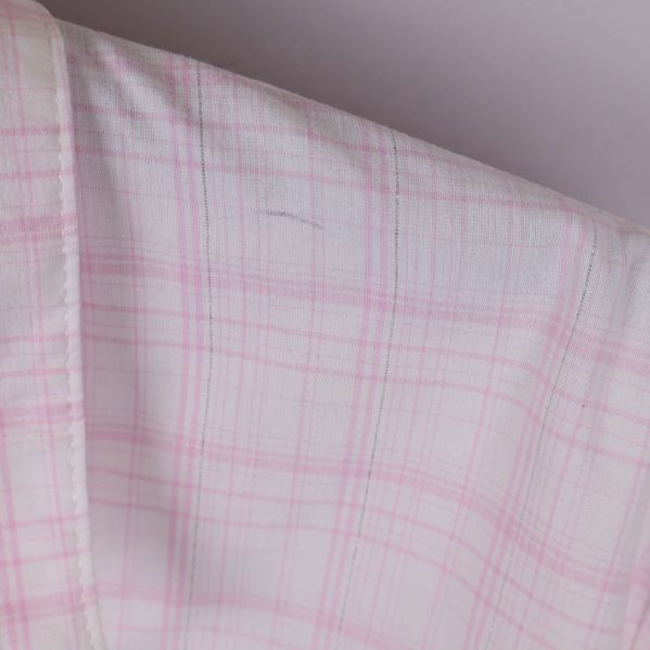 Närbild på rutigt tyg och axelparti