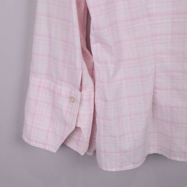 Närbild på skjortans nederkant och ärmslut med knapp