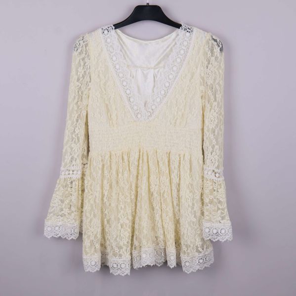 Krämvit blus i spets med klockärmar och V-ringning